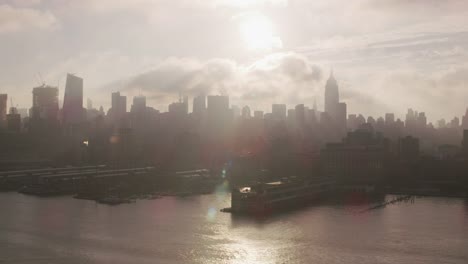 Fliegen-auf-Hudson-River-bei-Sonnenaufgang-mit-Manhattan-Gebäude-und-Piers.