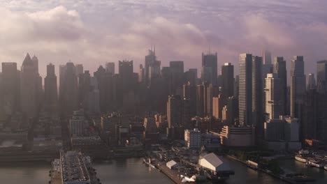 Fliegen-auf-Hudson-River-bei-Sonnenaufgang-mit-Manhattan-Gebäude-und-Piers.