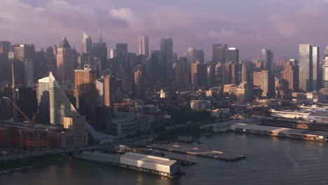 Vuelo-del-río-Hudson-hasta-al-amanecer-con-muelles-y-edificios-de-Manhattan.