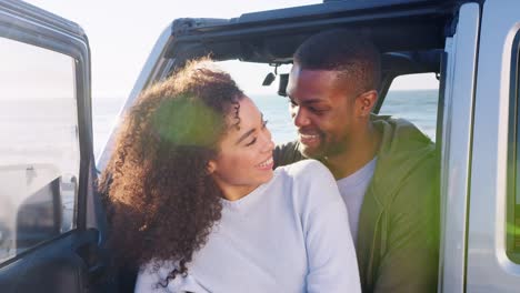 Young-mixed-race-couple-embracing-by-car,-close-up