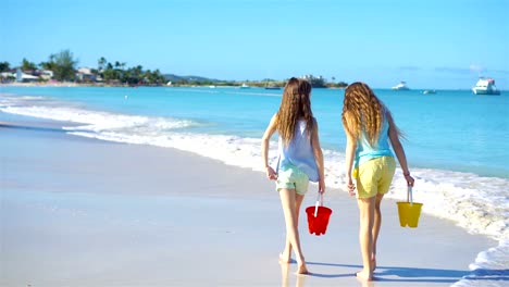 Adorables-niñas-caminando-por-la-playa-y-divertirse-juntos