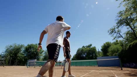 Hombres-jugando-al-tenis-contra-la-pared