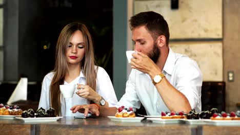 Man-and-woman-at-the-bar-having-a-coffee-and-using-a-mobile-phone