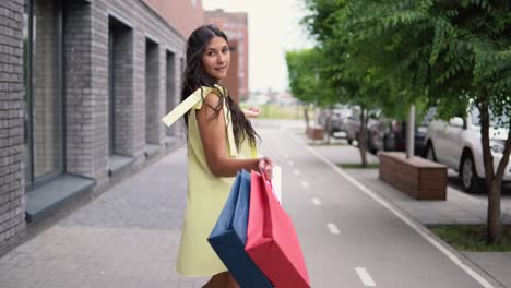 Chica-joven-en-un-vestido-largo-después-de-compras-con-buen-humor.-4K