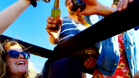 Group-of-friends-toasting-beer-bottles-in-the-car-4k