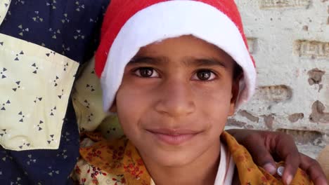 Close-up-of-two-kid-brothers-with-Santa-hats-smiling