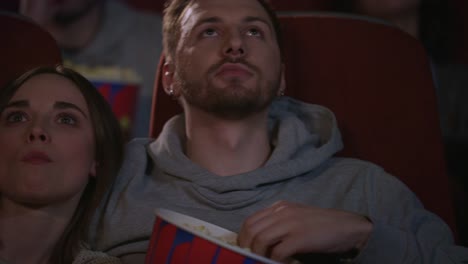 Close-up-of-young-people-faces-watching-movie-at-cinema-theater