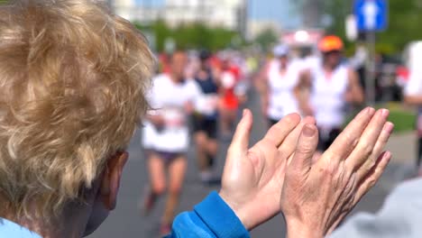 Senior-woman-cheering-runners-and-clapping-hands-in-4k-slow-motion-60fps