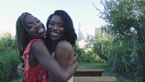 Slow-motion-of-two-African-American-women-hugging-and-smiling-at-camera-in-LA