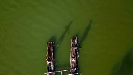 Vista-aérea-de-niños-saltando-en-el-agua-en-el-lago-al-atardecer,-en-concepto-de-la-vida-de-campo-alegre