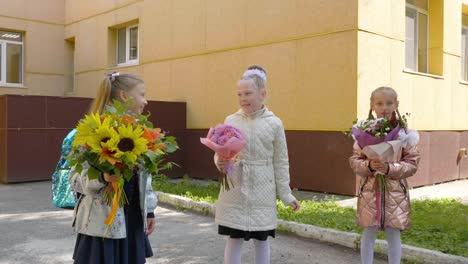 Glücklich-Schulmädchen-mit-Bouquet-Blumen-springen-und-spielen-Frontkamera.