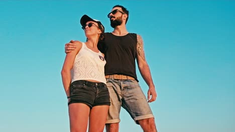 joven-mujer-y-hombre-disfrutando-del-atardecer-frente-a-un-cielo-azul