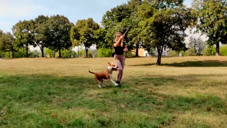 Chica-engañando-a-su-perro-a-buscar-en-el-Parque