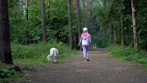 niña-se-hace-caminando-con-un-perro-en-el-bosque