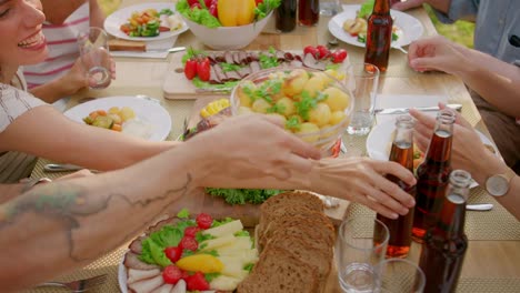 Top-Down-Moving-Shot:-Big-Family-Garden-Party-Celebration,-People-Eating,-Drinking,-Passing-Dishes.-Holiday-Fun-on-a-Sunny-Summer-Day.