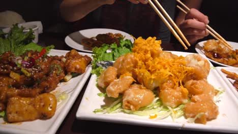 close-up-panning-of-group-of-people-eating-a-chinese-feast