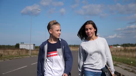 two-young-teenagers-walking-and-talking,-smiling