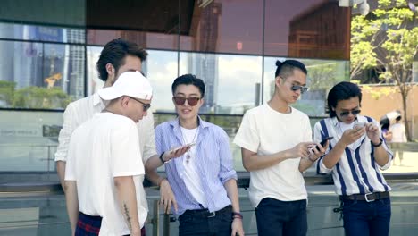 young-asian-adult-men-hanging-out-on-street-looking-at-mobile-phone