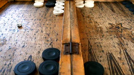 Zwei-junge-Männer-spielen-Backgammon-auf-einem-Holztisch-rollende-Würfel-und-verschieben-das-Stück.