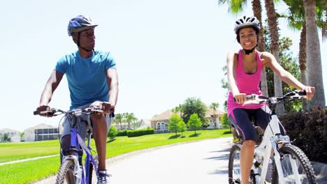 Young-active-African-American-couple-exercise-cycling-outdoors