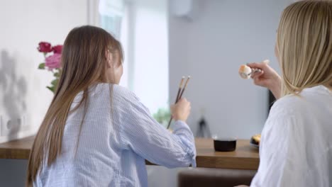 Woman-eating-sushi-and-looking-at-friends