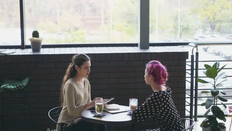 Artist-sketching-female-model-at-cafe