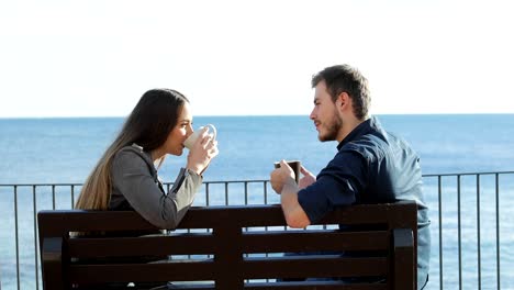 Couple-talking-and-drinking-on-the-beach