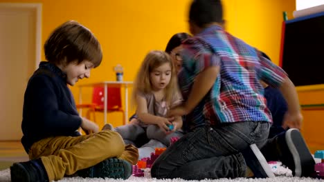 Unbeschwerte-Kinder-im-Vorschulalter-entspannend-im-Spielzimmer