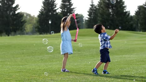 Joyful-little-asian-kids-playing-with-soap-bubbles