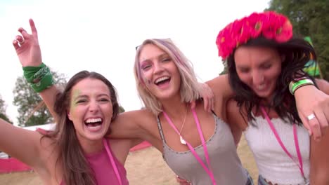 Three-young-female-friends-having-fun-at-a-music-festival