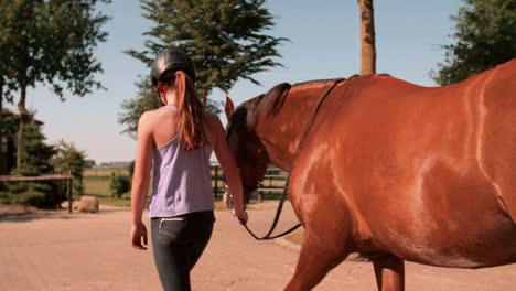 Girl-a-escasos-pasos-de-distancia,-con-su-caballo-en-un-patio-al-aire-libre