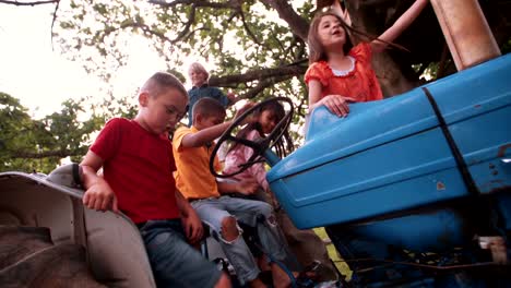 Niños-jugando-en-una-antigua-tractor-en-la-granja