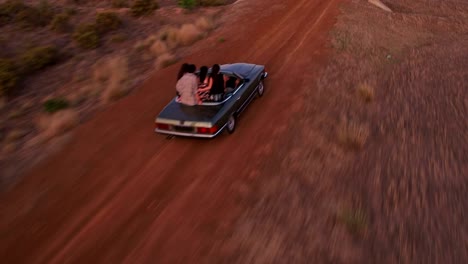 Hipster-friends-carefree-in-vintage-convertible-car-during-road-trip