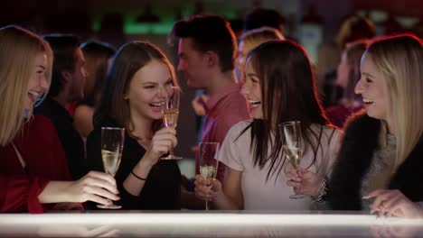 Cuatro-chicas-atractivo-en-el-bar-en-Club-plantear-sus-copas-de-champaña