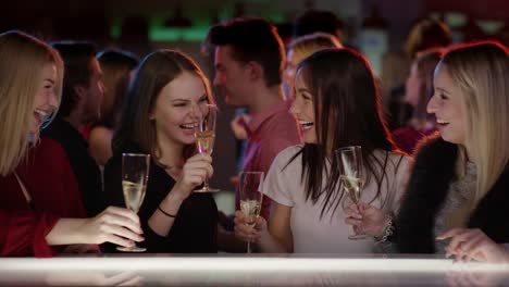 four-attractive-girls-at-bar-in-club-raising-their-champagne-glasses