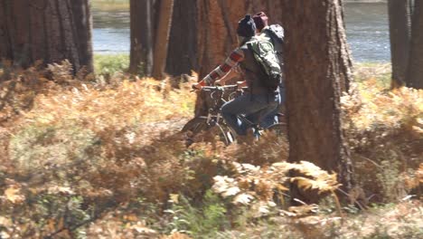 Paar-sprechen-mit-mountain-bikes,-wie-sie-im-Wald,-eng-Pfanne