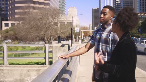 African-American-couple-talking-at-a-waterfront-in-a-city