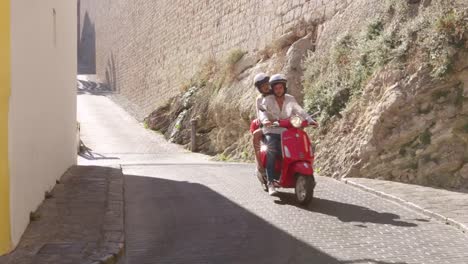 Young-couple-riding-on-a-scooter,-Ibiza,-Spain,-shot-on-R3D