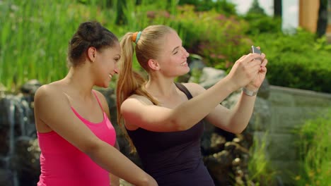 Dos-chicas-haciendo-muecas-cuando-se-toma-foto-con-el-teléfono.-Retrato-del-uno-mismo