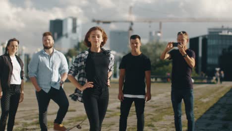 Teenage-Girl-Performing-Modern-Dance-for-Group-of-Friends-Outdoors-in-Urban-Environment.