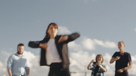 Teenage-Girl-Performing-Modern-Dance-for-Group-of-Friends-Outdoors-in-Urban-Environment.