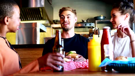 Amigos-comer-hamburguesa-con-cerveza