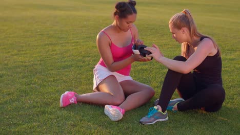 Young-women-viewing-at-vr-headsed-in-hands.-Women-friends-examine-vr-device