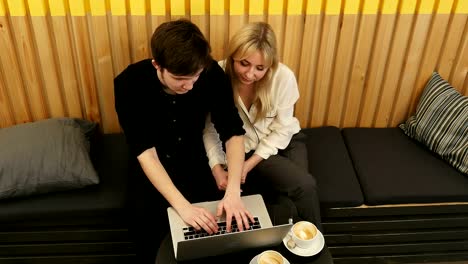 Detached-couple-using-laptop-computer-in-coffee-shop