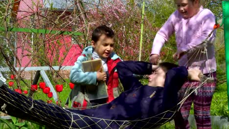 Niños-de-diferentes-edades-jugando-cerca-de-la-hamaca