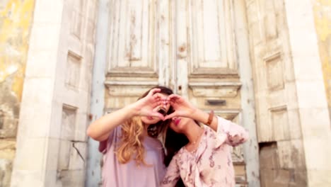 Female-best-friends-making-a-heart-symbol-with-their-hands