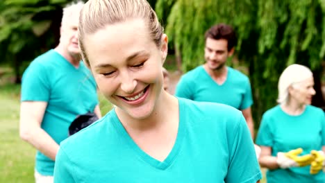 Female-volunteer-holding-recycle-bin-in-the-park