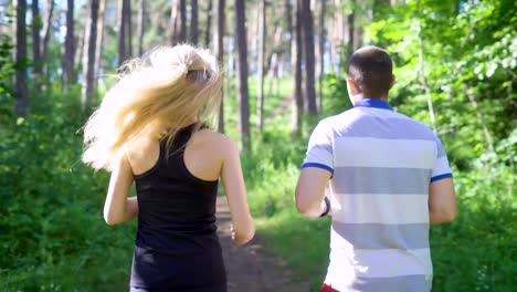 Modern-jogging-in-the-forest.-Couple-running.-Woman-setting-timer