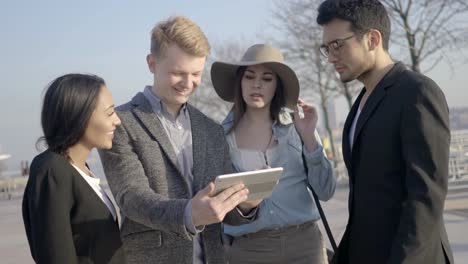 Diverse-Group-of-Young-Good-Looking-People-Looking-at-a-Digital-Tablet.-Causing-Chereful-Atmosphere-and-Merry-Mood.