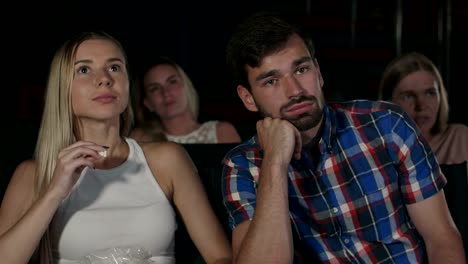 Young-people-watching-a-boring-movie-at-the-cinema,-one-guy-is-sleeping